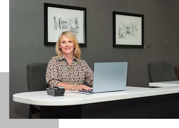 A woman sitting at a table with a laptop.