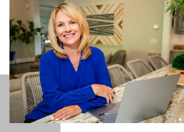 A woman sitting at a table with a laptop.