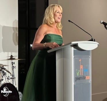 a woman giving a speech and smiling